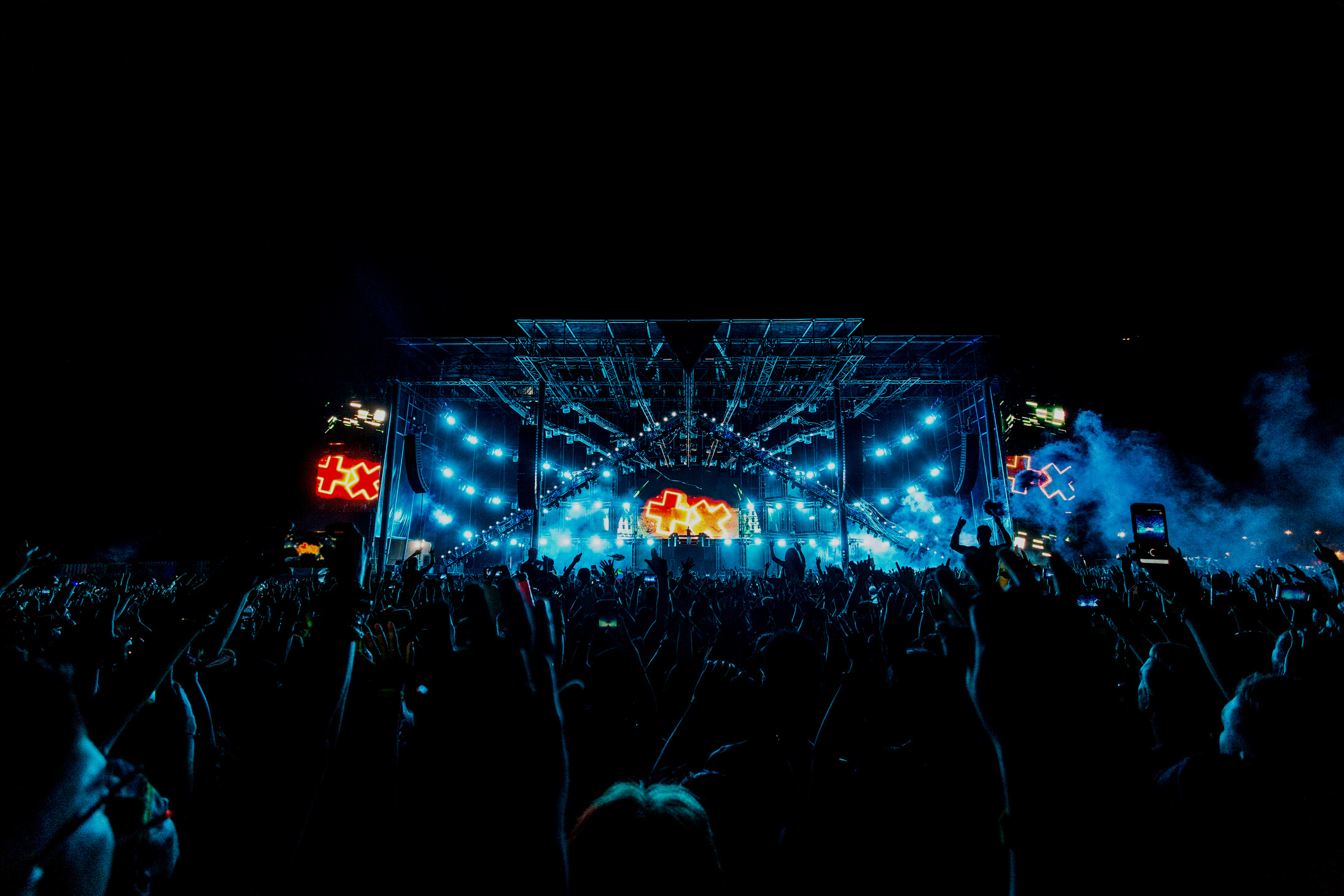 Crowd in Front of Blue and Orange Stage during a Concert at Night